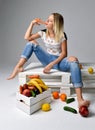 Woman eating carrot near box with fresh organic vegetables Royalty Free Stock Photo