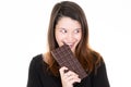 Woman eating chocolate bar isolated over white background look side