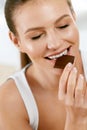 Woman Eating Chocolate. Beautiful Girl With Sweets. Royalty Free Stock Photo