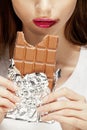 Woman eating chocolate, close up hands with manicure french nails holding candy, beautiful fingers Royalty Free Stock Photo