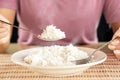 Woman eating cooked hot rice by spoon in a white plate Royalty Free Stock Photo