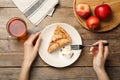 Woman eating delicious apple pie with ice cream at wooden table, top view Royalty Free Stock Photo