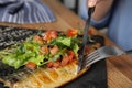 Woman eating delicious grilled fish with vegetables at table, closeup Royalty Free Stock Photo