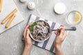 Woman eating delicious mushrooms at marble table