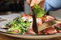 Woman eating delicious salad with roasted duck breast at wooden table, closeup Royalty Free Stock Photo