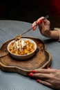 Woman eating dessert in a restaurant. Dessert on a wooden stand. Close-up of hands. Royalty Free Stock Photo