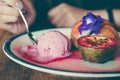 Woman eating a dish of Choux cream , rose ice-cream and passion fruit with beautiful decoration Royalty Free Stock Photo