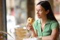 Woman eating doughnut in a terrace Royalty Free Stock Photo