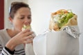 Woman eating Falafel warp in a street food restaurant