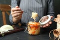 Woman eating fermented cabbage at black table, closeup