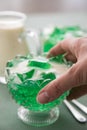 Woman eating green woodruff jelly and vanilla custard with spoon