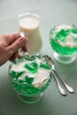 Woman eating green woodruff jelly and vanilla custard with spoon Royalty Free Stock Photo