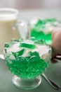 Woman eating green woodruff jelly and vanilla custard with spoon