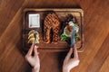 Woman eating grilled salmon steak served on wooden board with lemon and lettuce