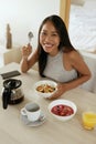 Woman eating healthy breakfast at home in morning at table