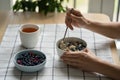 Woman eating healthy breakfast with oatmeal porridge with summer berries. Dieting, weight loss.