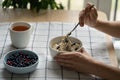 Woman eating healthy breakfast with oatmeal porridge with summer berries. Dieting, weight loss. Royalty Free Stock Photo