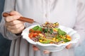 Woman eating healthy quinoa salad with vegetables from plate Royalty Free Stock Photo
