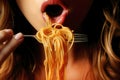 Woman eating holding a fork of spaghetti near her mouth close up