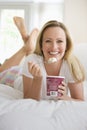 Woman Eating Ice Cream in Bed Royalty Free Stock Photo