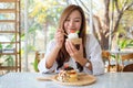 A woman eating ice cream with a mixed berries pancakes and whipped cream by wooden spoon Royalty Free Stock Photo
