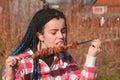 Woman eating meat shashlik barbecue on a skewer in the backyard in the spring on a Sunny day.