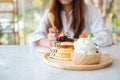A woman eating a mixed berries pancakes with ice cream and whipped cream Royalty Free Stock Photo