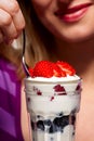 Woman eating a mixed berry parfait