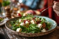 Woman eating mixed salad with lambs lettuce feta