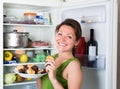 Woman eating pancake near refrigerator Royalty Free Stock Photo