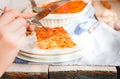 Woman eating piece of tasty hot lasagna served on a white plate. Italian cuisine, menu, recipe. Homemade meat lasagna. Close up, Royalty Free Stock Photo