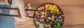 Woman eating Raw Organic Poke Bowl with Rice and Veggies close-up on the table. Top view from above horizontal BANNER Royalty Free Stock Photo