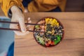 Woman eating Raw Organic Poke Bowl with Rice and Veggies close-up on the table. Top view from above horizontal Royalty Free Stock Photo