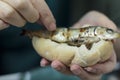 Woman eating roasted sardines with her hands