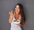 Woman is eating a salad, healthy food and nutrition, portrait and vegetables  on wall background. Happy, vegan Royalty Free Stock Photo