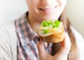 Woman eating sandwich with cheese and green vegetables onion