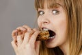 Woman eating sandwich, taking bite