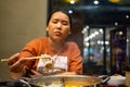 Woman eating shabu by using bamboo chopsticks