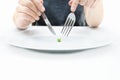 Woman eating a small green pea using knife and fork. Extreme weight loss diet concept Royalty Free Stock Photo