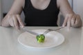 A hungry woman on a weight loss diet. Empty plate with a vegetable. Low calorie diet