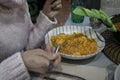 Woman eating a soupy rice. A highly demanded food in Spain