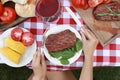 Woman eating steak at table outdoors, top view. Barbecue party