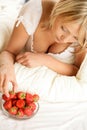 Woman eating strawberry with cream