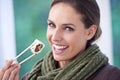 Woman, eating sushi and healthy food in portrait, lunch or dinner, Japanese cuisine and seafood with chopsticks