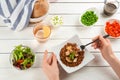 Woman eating tasty brown rice with meat and vegetables at white table, closeup Royalty Free Stock Photo