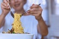 Woman eating tasty Italian spaghetti on white bowl with spoon and fork. Royalty Free Stock Photo