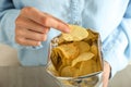 Woman eating tasty potato chips, closeup