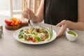 Woman eating tasty quinoa salad at table Royalty Free Stock Photo