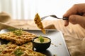 Woman eating tasty squash waffles with sauce, closeup
