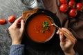 Woman eating tasty tomato soup on dark background Royalty Free Stock Photo